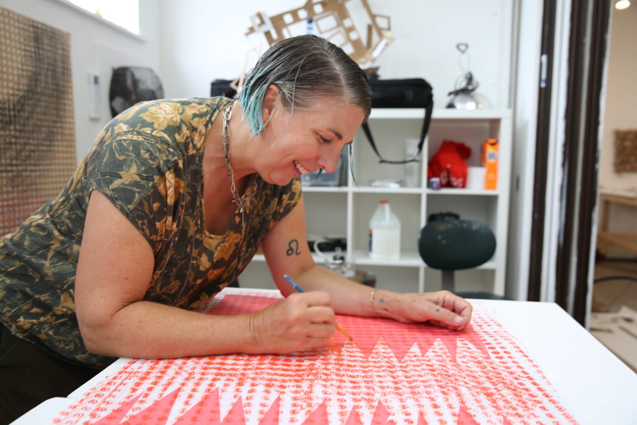 An artist works on a piece of textile art in her studio.